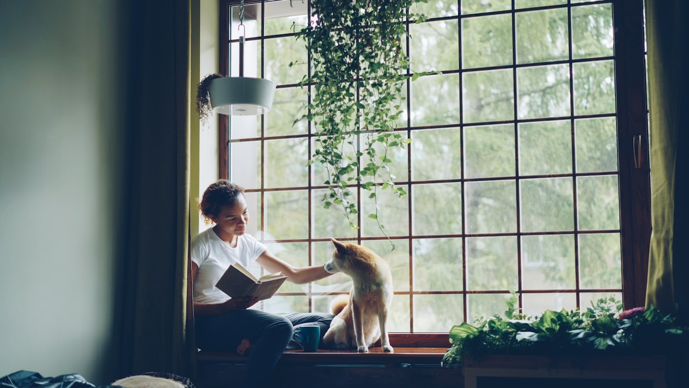 Evinde köpeğiyle vakit geçiren bir kişi